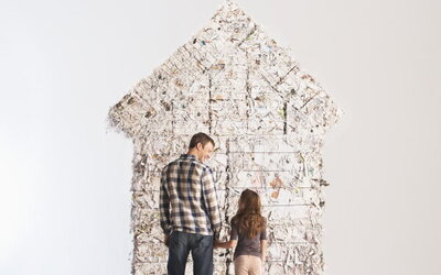 Zwei Personen betrachten ein Haus aus Recyclingstoffen