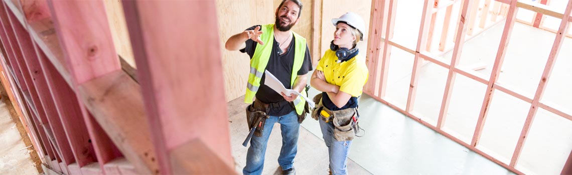 Zwei Baufachleute besprechen sich auf einer Baustelle